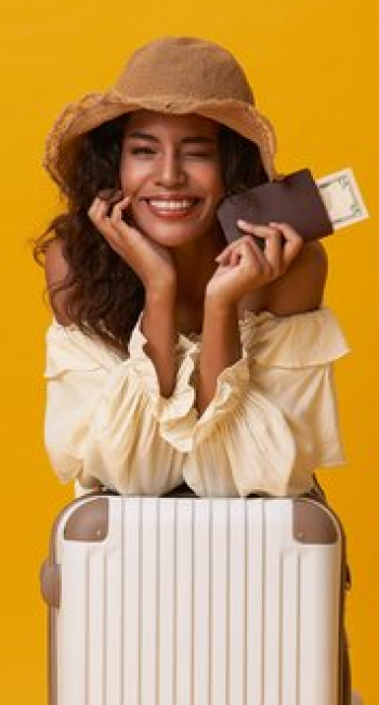 happy-african-woman-sitting-with-suitcase-isolated-yellow-background (1)